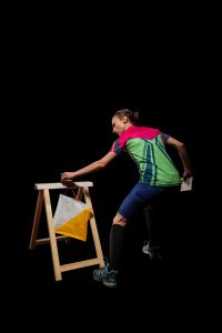 Woman punching at control point, taking part in orienteering competitions. Isolated on black. File contains clipping path